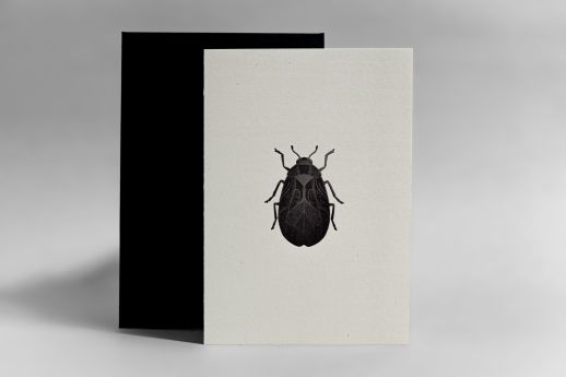 Foil-stamped beetle note card on cannabis stock with black envelope.
