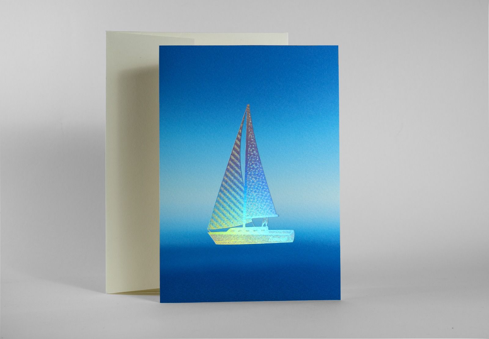 Sailboat greeting card foil stamped with holographic silver foil and digital printing on Gesso 300gsm stock, supplied with ivory envelope.